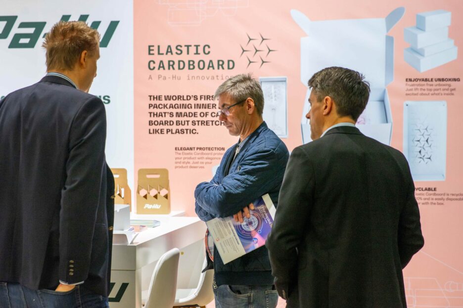 Kolme henkilöä PacTec-messuilla.