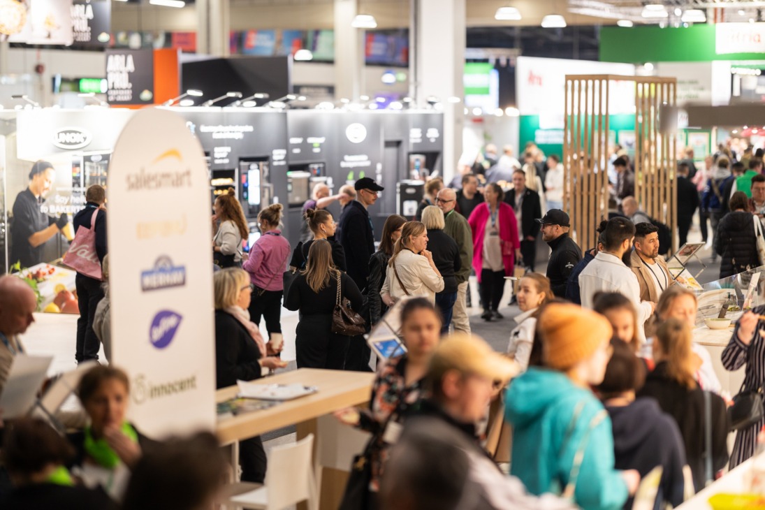 Kuva messuhallista, jossa on paljon ihmisiä tutustumassa eri osastoihin.